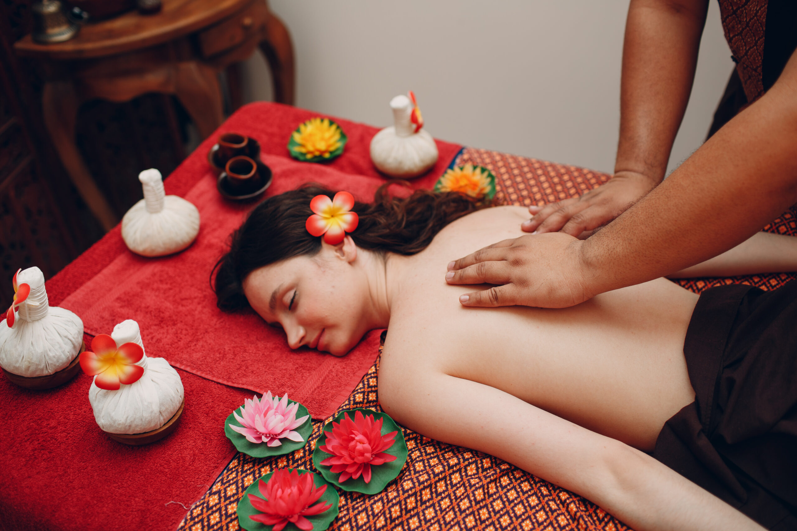 Thai man making classical thai massage procedure to young woman at beauty spa